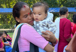A mother hugs her baby after receiving flood relief assistance