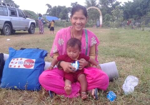 Ever since Bismati Tharu started living in a shared tent following the floods, she had no spare clothes to change for herself and her baby.  Photo: © UNFPA Nepal/Purna Nepali