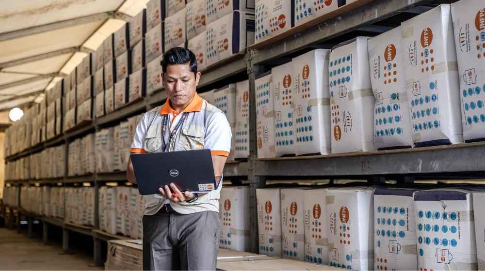 Arjun Basnet logging prepositioned humanitarian supplies at UNFPA warehouse. ©UNFPA Nepal / Luis Tato