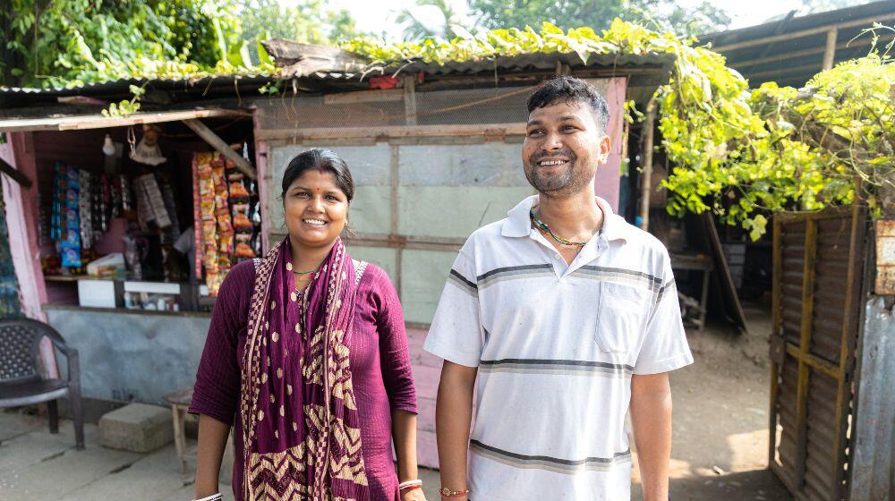 A couple poses in front of their shop